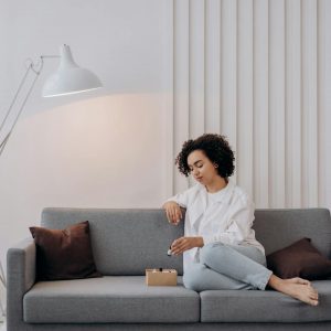 A woman enjoying aromatherapy on a stylish sofa, embracing relaxation and wellness.