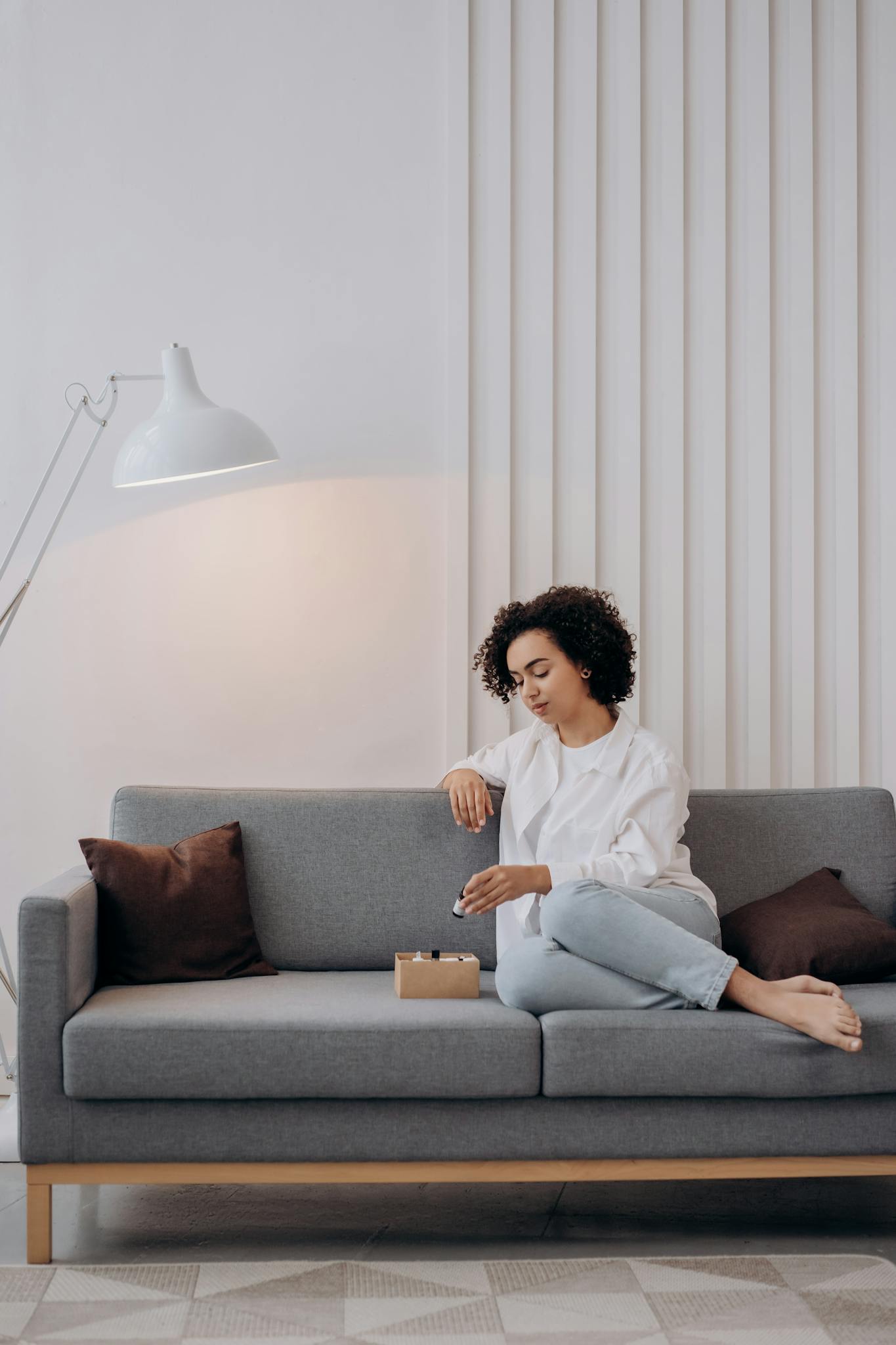 A woman enjoying aromatherapy on a stylish sofa, embracing relaxation and wellness.